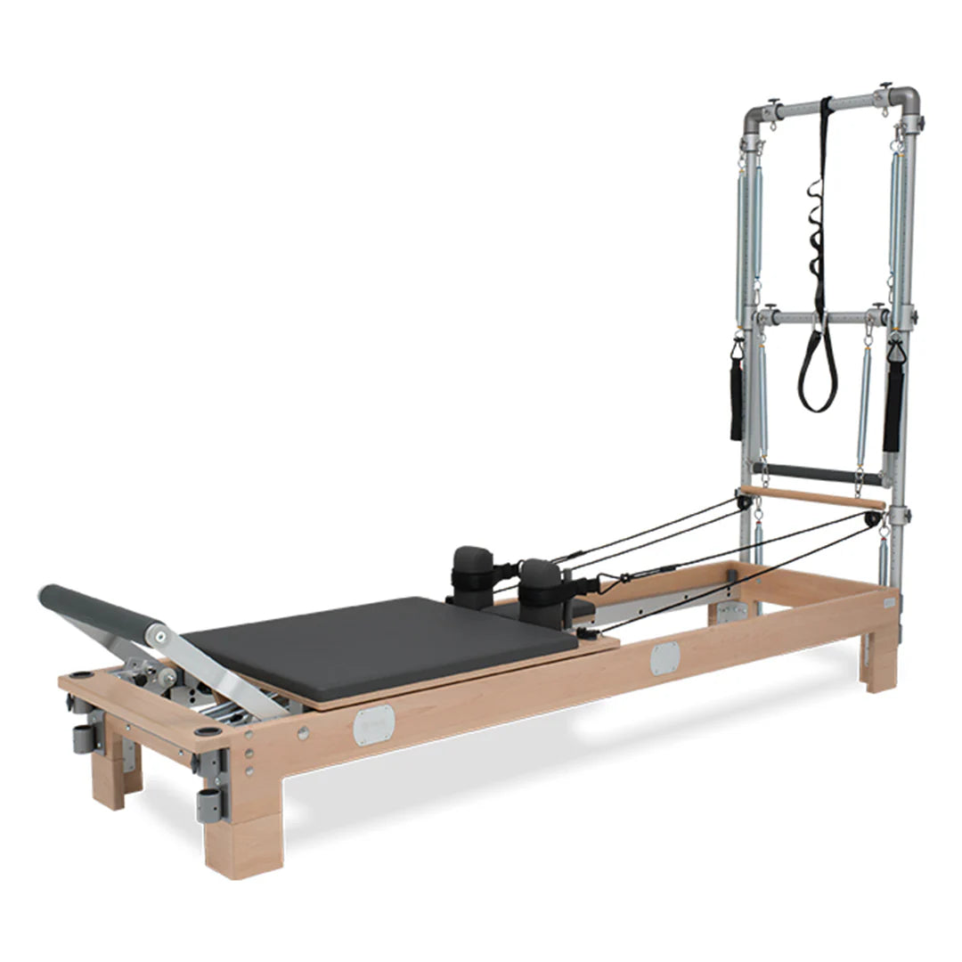 BASI Systems Reformer with Tower featuring adjustable pulleys, cushioned carriage, footbar, and push-through bar for professional Pilates training.