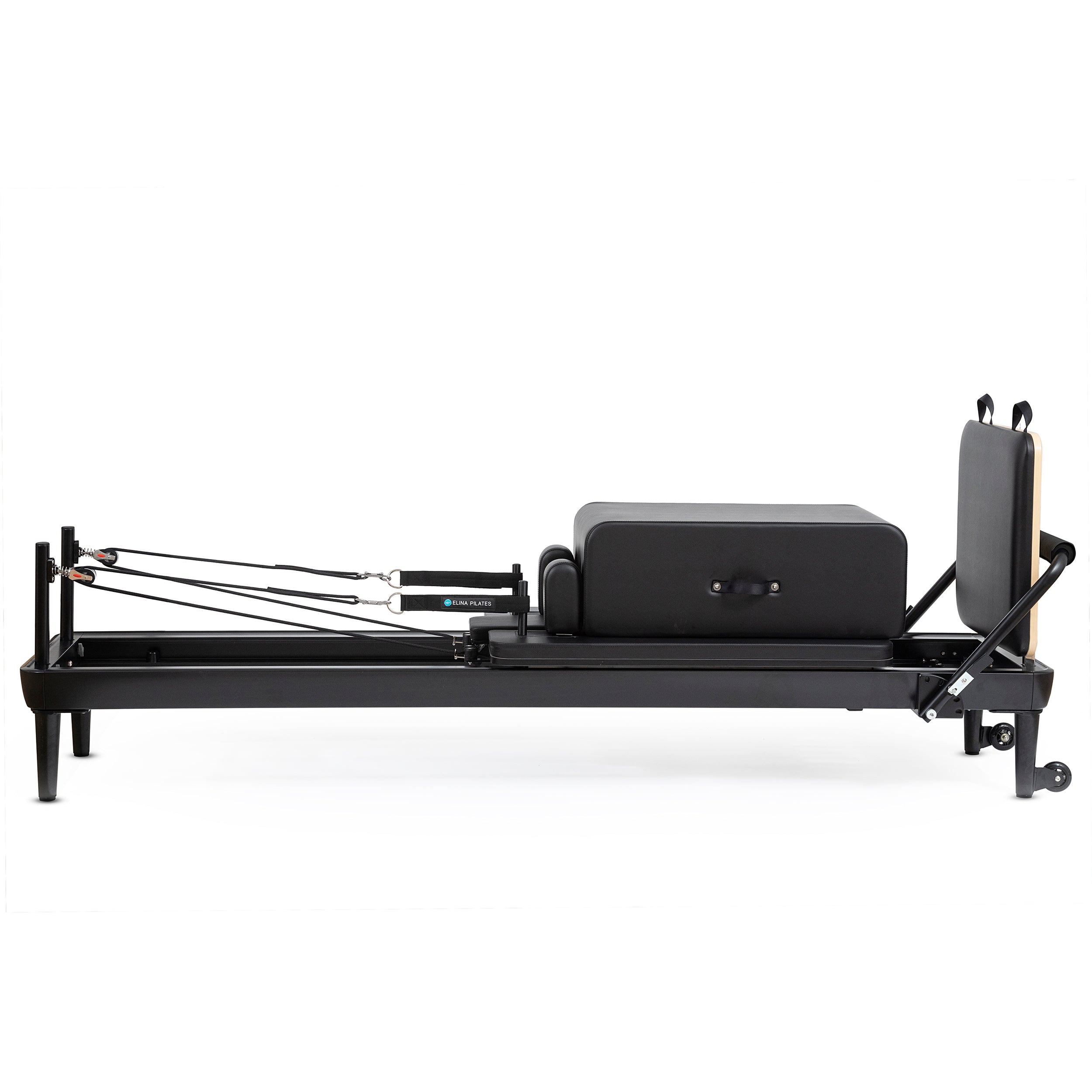 A black-framed pilates reformer with a matching black bag positioned beside it.