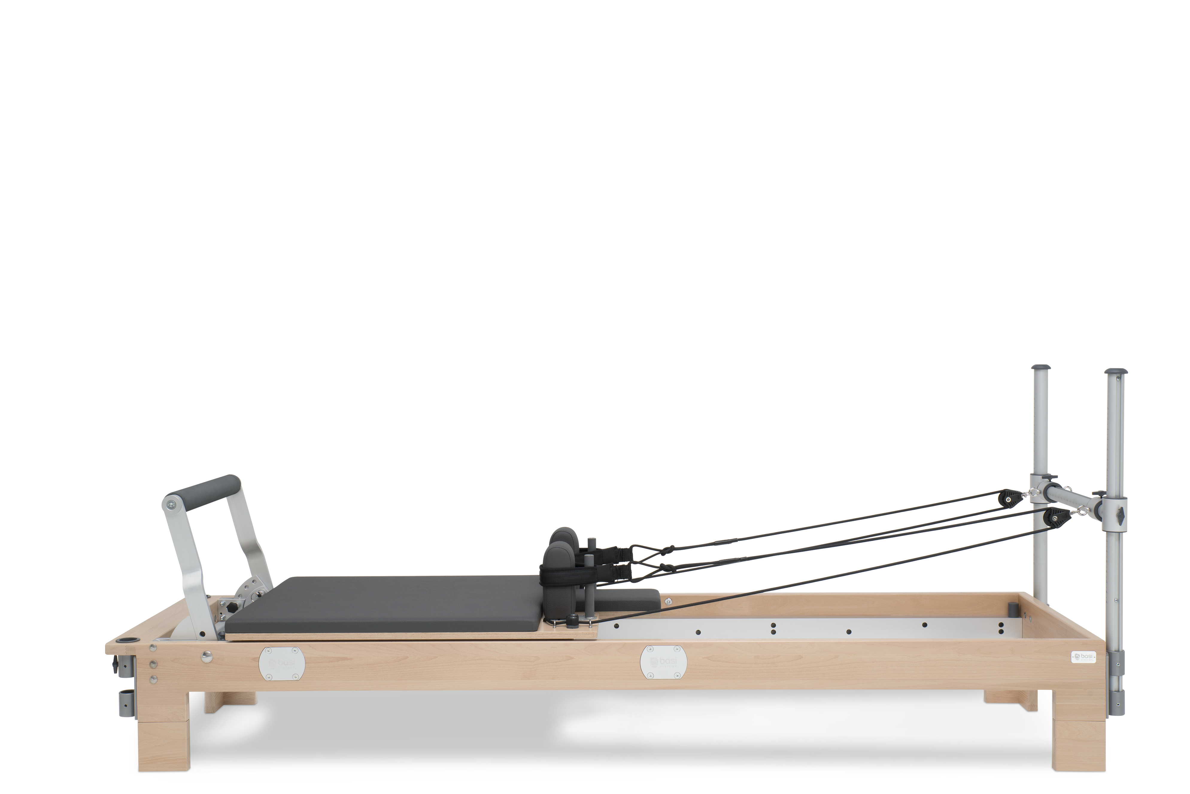 Premium wooden Pilates Reformer machine featuring a sliding carriage, padded footbar, adjustable spring