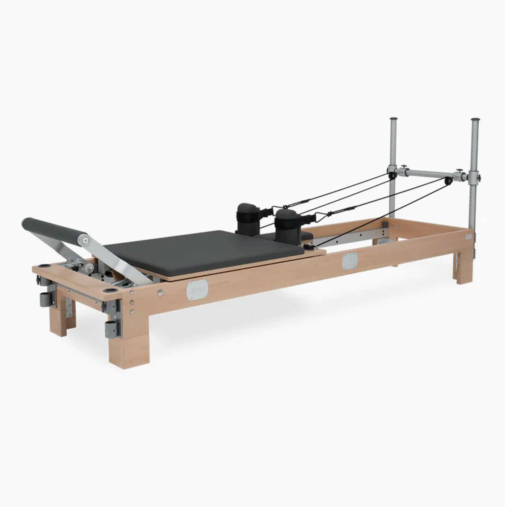 Premium wooden Pilates Reformer machine featuring a sliding carriage, padded footbar, adjustable spring