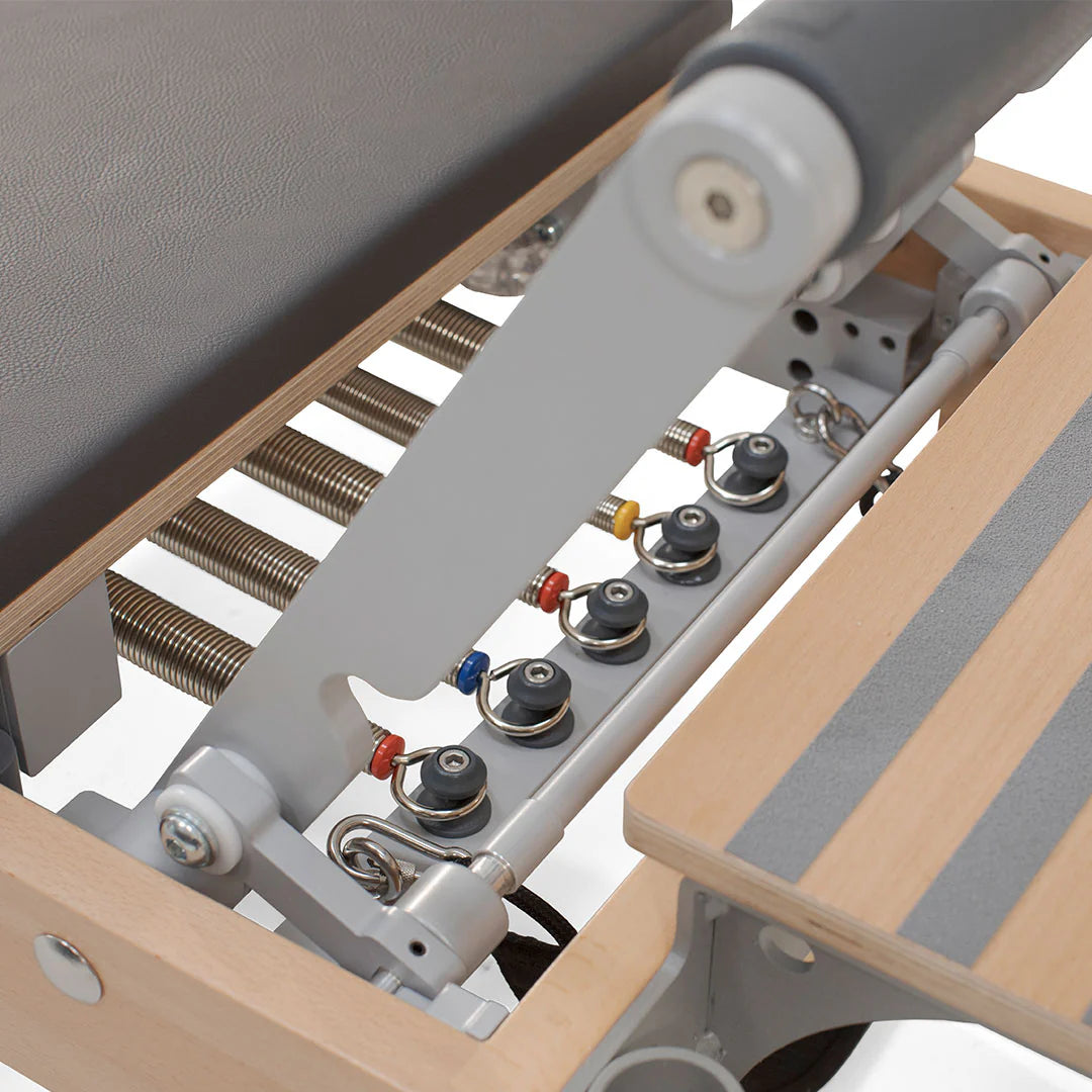 Close-up of a pilates machine showing the seat and handle, highlighting its design and functionality for workouts.