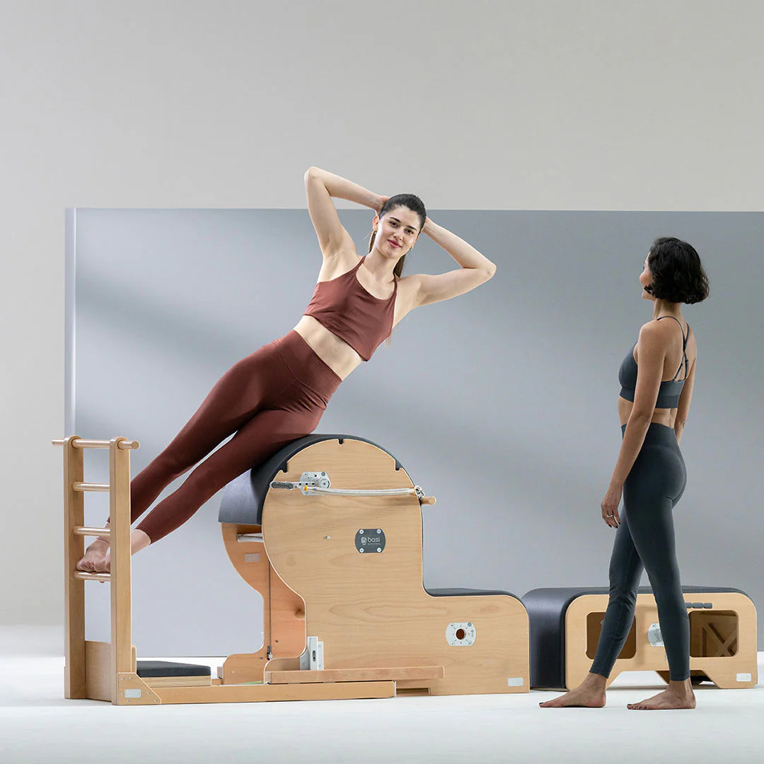 BASI Systems Ladder Barrel with adjustable curved cushion and standing platform for Pilates exercises