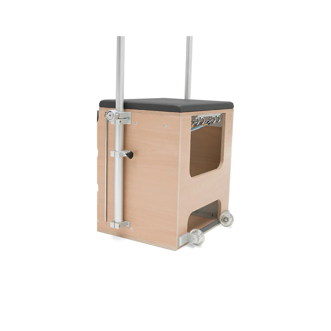 Pilates Wunda Chair with split pedals, handles, springs, and cushioned wooden seat.