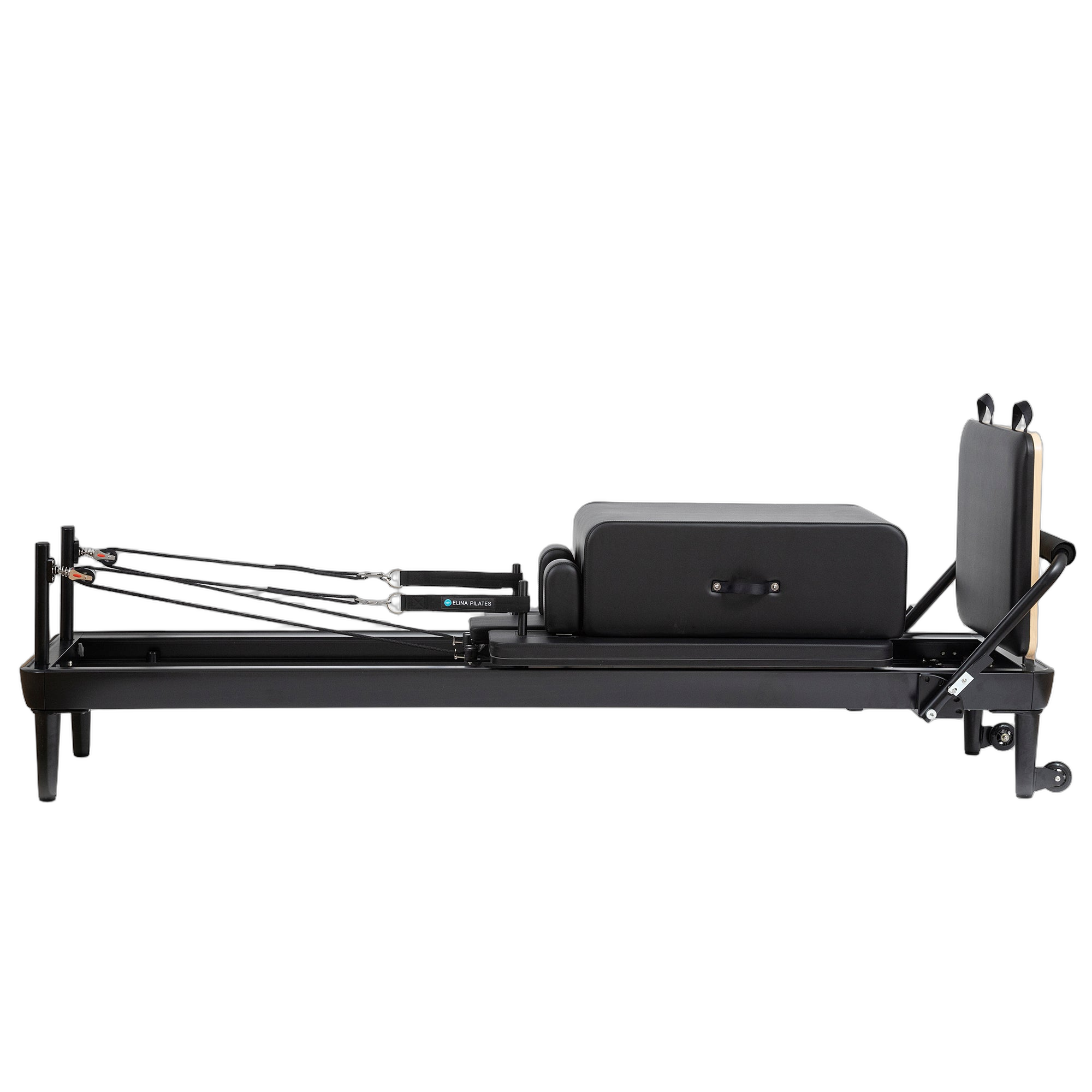 A black-framed pilates reformer with a matching black bag positioned beside it